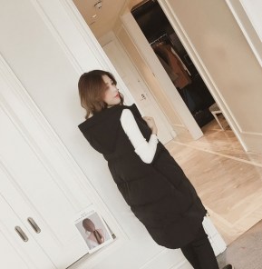 Длинная женская дутая жилетка с капюшоном и большими накладными карманами фото